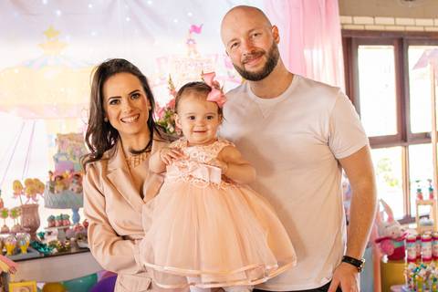 Mãe, Pai e Filha na frente da Decoração de Festa de aniversário Infantil de um ano da Helena, filha da @blogbytali com tema de Circo '