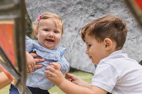 irmãos brincando com irmã bebê no gramado do  Memorial Ucraniano no Parque Tingui '