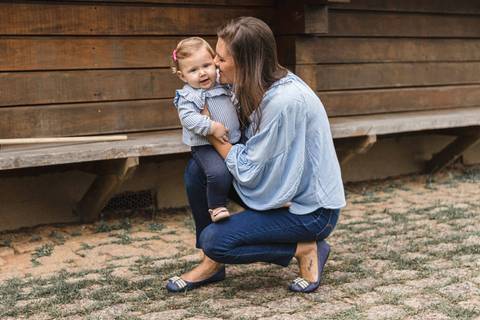 Mãe com filha bebê no colo   no gramado do  Memorial Ucraniano no Parque Tingui '