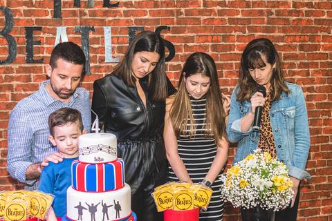 família fazendo oração na mesa de aniversário infantil antes do parabéns no Buffet Infantil Play House em Curitiba'