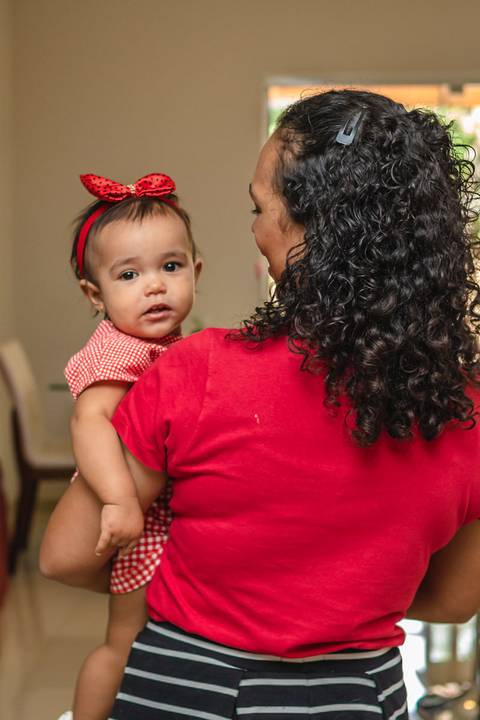 mãe com bebê no colo em casa '