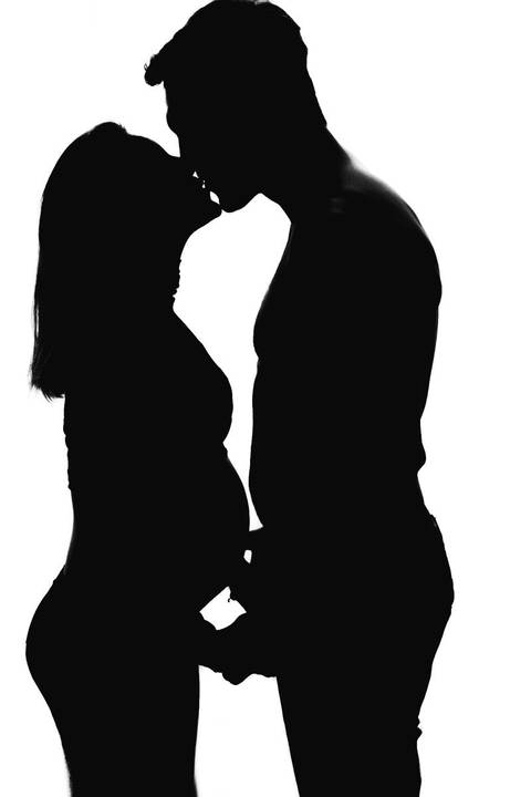 casal com mulher grávida se beijando '