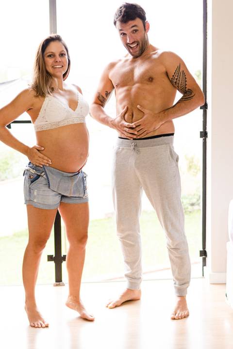 marido e  mulher grávida com a barriga na cama '