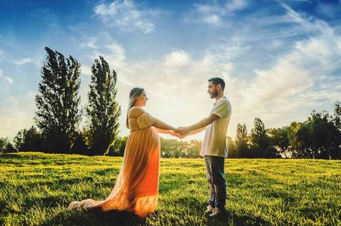 Casal com mãos unidas em campo verde com casamento esperado'