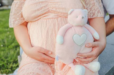 Mulher grávida em rosa com carinho afetuoso no repouso'