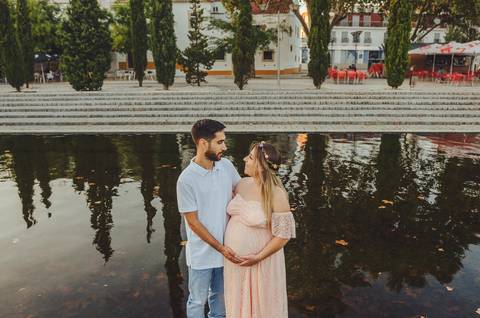 Casal em água com mulher grávida em momento de intimidade'