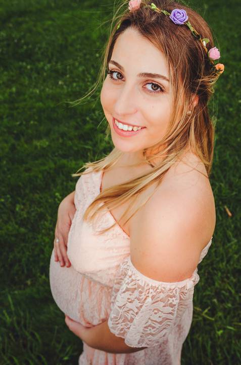 Mulher grávida com sorriso radioso em ambiente natural'