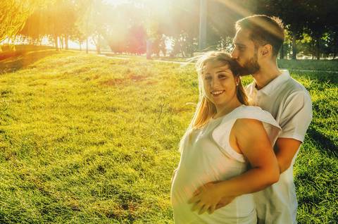 Mulher grávida de mãos descansadas em barriga redonda'