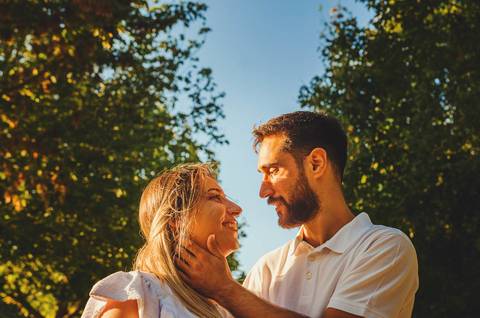 Casal conversando ao entardecer em ambiente florido'