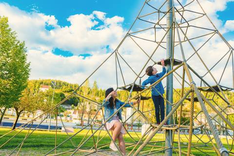 Menino brincando em estrutura de parque ao ar livre'