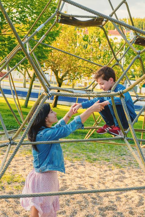 Menino em túnel de escalada com cores vibrantes'