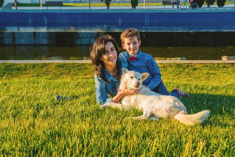 Família mãe e filho deitados em grama verde'