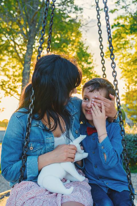 Filho beijando mãe em momento de cumplicidade e afeto'