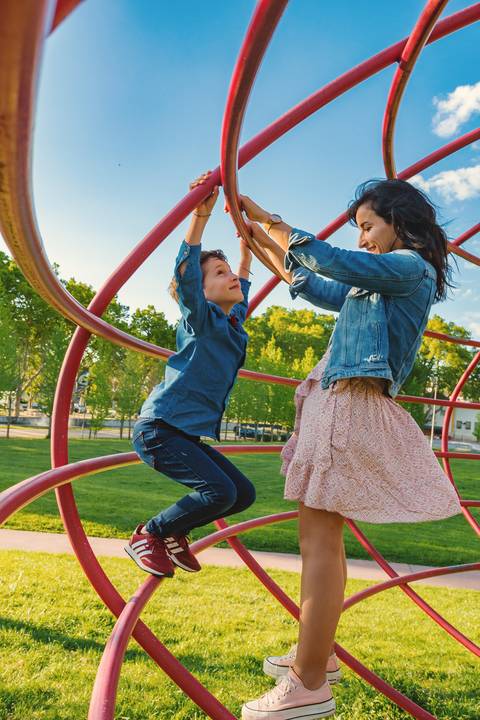 Mãe e filho abraço no parque com céu azul'