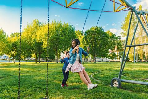 Criança em balanço no parque ao ar livre'