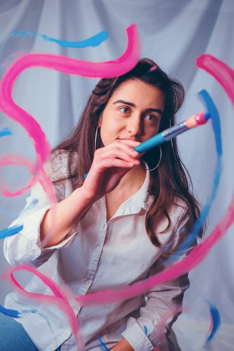 Mulher segurando pincel com pintura facial artística colorida'