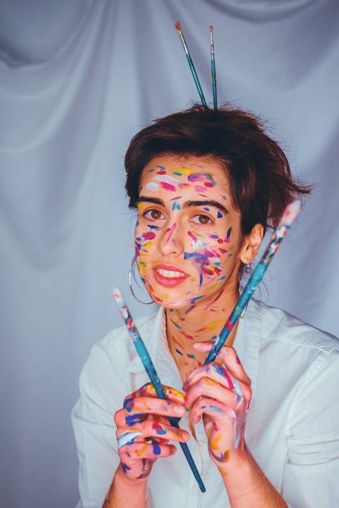 Mulher com pintura facial colorida em tons alegres'