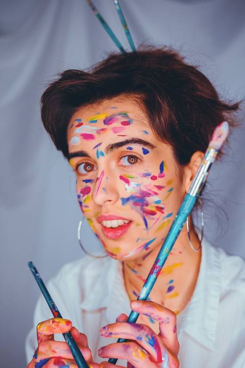 Mulher com pintura facial colorida em tons alegres'