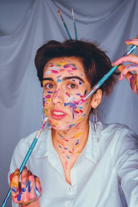 Mulher com pintura facial colorida em estilo artístico'