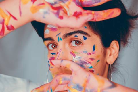 Retrato com pintura de rosto em cores vibrantes'