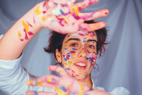 Mulher com pintura facial alegre mostrando expressão'