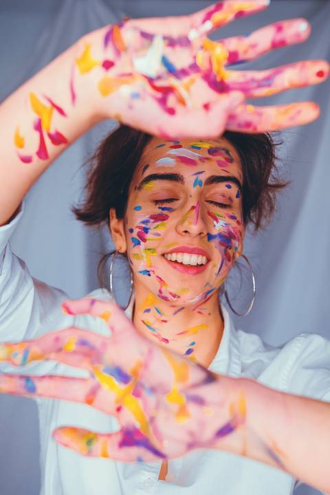 Detalhe de mulher com pintura facial em tons quentes'