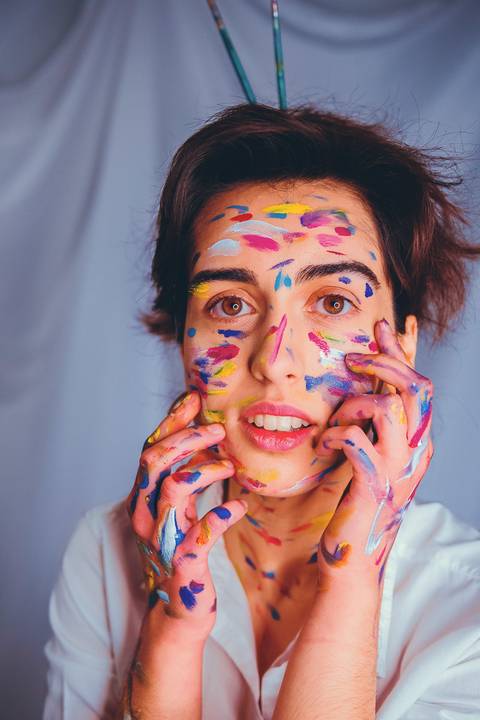 Detalhe de mulher com pintura facial em tons quentes'