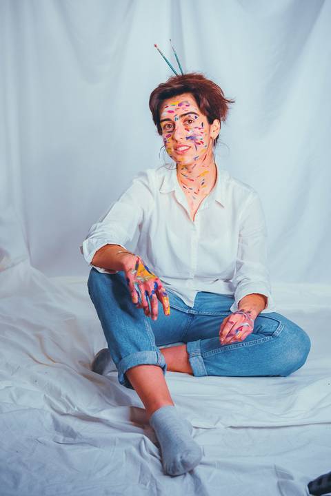 Mulher em pose sentada com pintura artística'