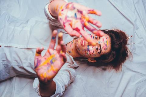 Mulher deitada com pintura de rosto vista do topo'