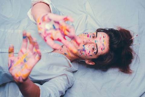 Mulher recostada mostrando pintura corporal artística'