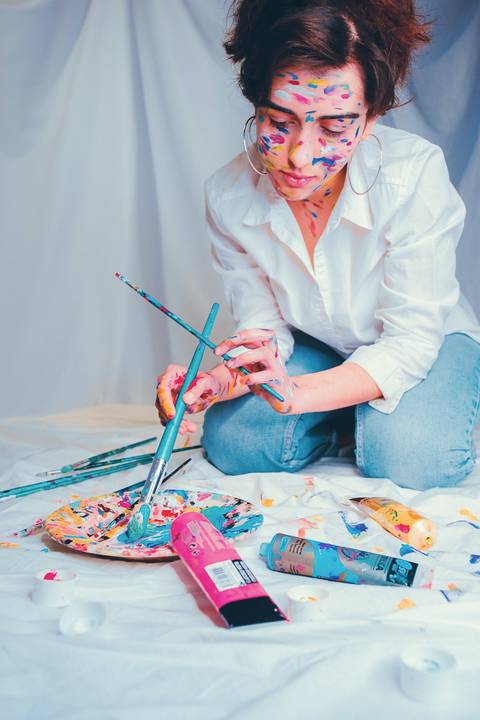 Mulher em composição artística com pintura facial colorida'