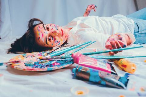 Mulher em composição overhead mostrando pintura facial'