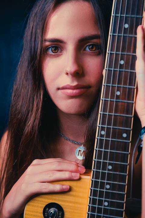 Close-up de mulher com violão em ambiente interno'