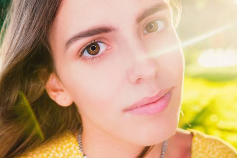 Close-up de mulher sorridente com luz natural suave'