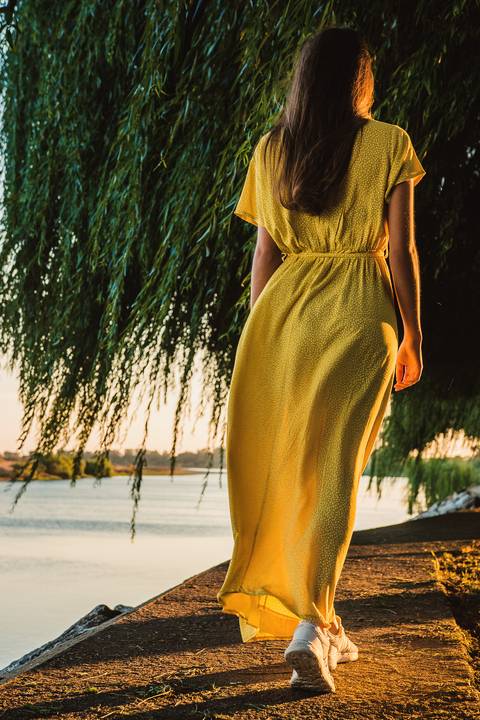 Mulher com violão em golden hour no parque dourado'