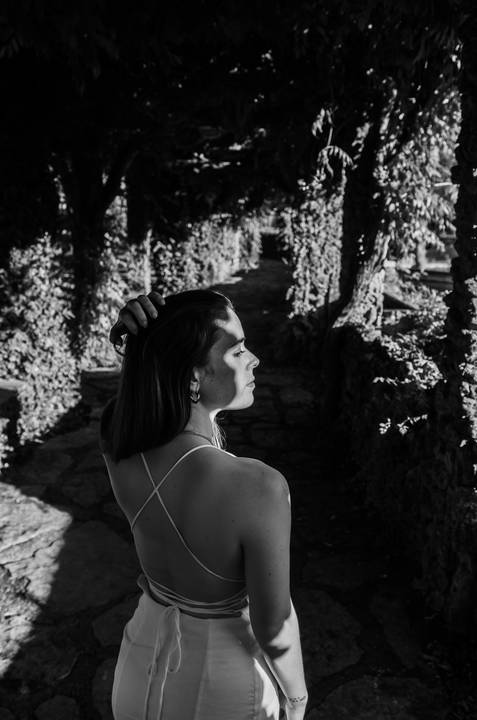Retrato em preto e branco de perfil com luz natural no jardim'