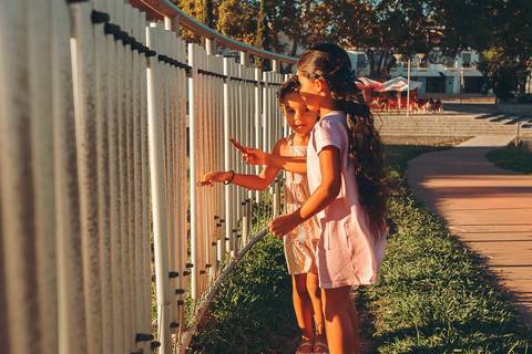 Sessão fotográfica da Família Teixeira na Barquinha Parque em Vila Nova da Barquinha, com iluminação dourada ao entardecer, retratando momento lifestyle com pais e filhos sorrindo'