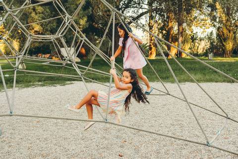 Menina em frente a paisagem natural verde de parque durante sessão fotográfica, retrato infantil individual ao ar livre com luz dourada ao pôr do sol, fotografia de criança em ambiente natural'