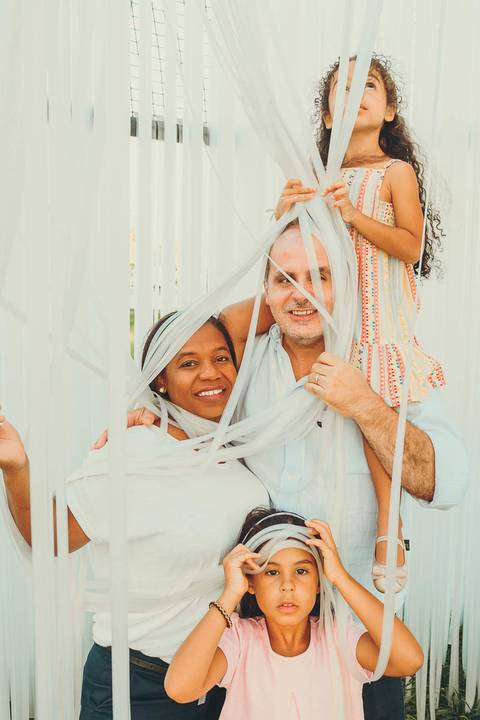 Mãe abraçada com filha em ambiente de parque ao entardecer, retrato de mãe e filha com abraço afetuoso durante sessão fotográfica ao ar livre com luz golden hour natural'