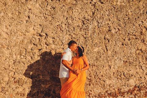 casal-gravida-se-beijando-marido-beijando-a-mulher-em frente-a-muro-do-castelo-de-ourem'
