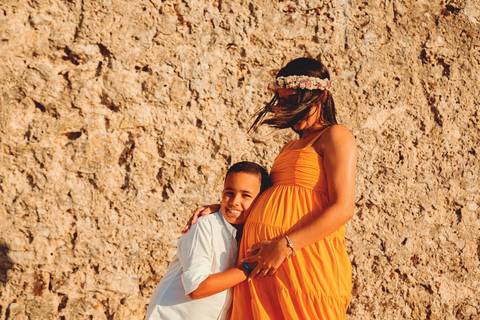 menino-filho-sorridente-abançando-a-mãe-gestante'