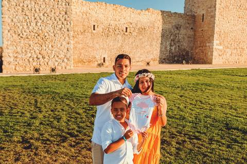 familia-mãe-pai-filho-gravida-segurando-roupinha-bebe'