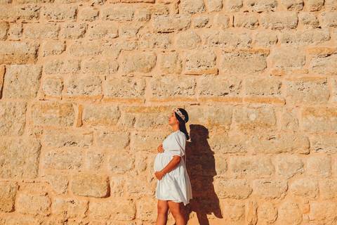 gravida-posando-segurando-a-barriga-em-frente-a-parede-do-castelo'