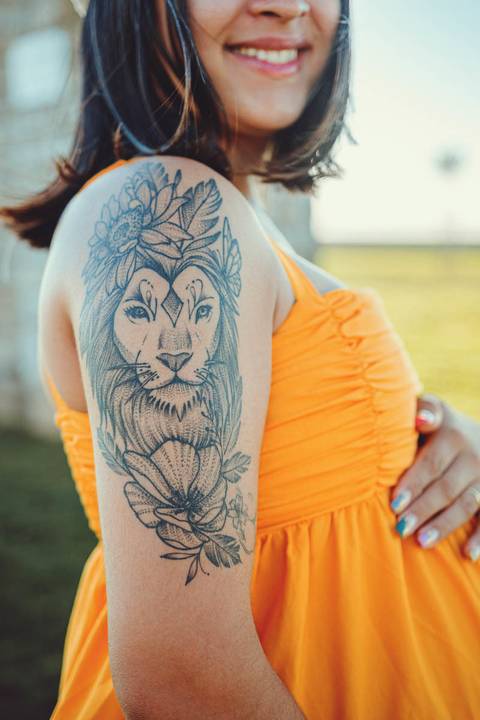 close-mulher-gravida-posando-de-perfil-mostrando-tatuagem-de-leão'