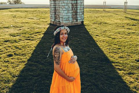 mulher-gestante-sorrindo-em-frente-a-estatua-no-patio-do-castelo-de-ourem'