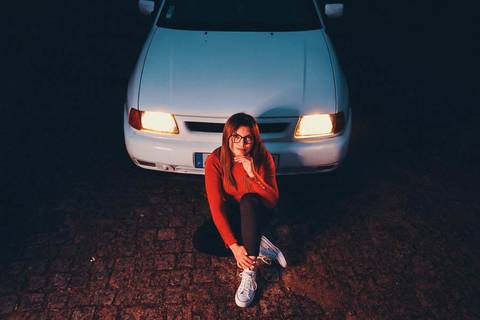 Myriam Correia em retrato noturno com o Seat Ibiza iluminado pelos faróis na Quinta da Cardiga, Golegã. A luz do carro cria uma atmosfera cinematográfica única. Duo Capuano Fotografia.'