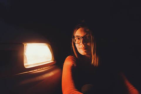 Myriam Correia em close-up noturno iluminada pela luz quente do Seat Ibiza durante sessão de retrato feminino na Quinta da Cardiga, Golegã. Expressão serena e atmosfera íntima. Duo Capuano Fotografia.'