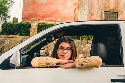 Myriam Correia debruçada na janela do seu Seat Ibiza durante sessão de retrato feminino na Quinta da Cardiga, Golegã. Uma pose descontraída e autêntica que reflete a sua personalidade. Duo Capuano.'