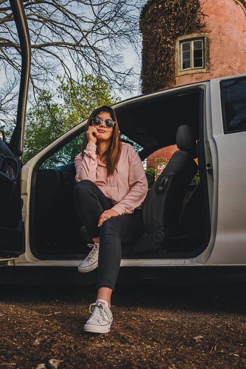Myriam Correia sentada na porta aberta do seu Seat Ibiza com look rosa durante sessão de retrato individual na Quinta da Cardiga, Golegã. Uma pose casual e elegante. Duo Capuano Fotografia.'