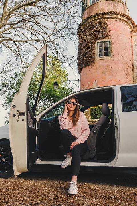 Myriam Correia com óculos de sol ao telefone durante sessão de retrato feminino na Quinta da Cardiga, Golegã. Um momento descontraído e cheio de autenticidade com o Seat Ibiza. Duo Capuano Fotografia.'